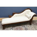 A Victorian stained mahogany scroll end chaise longue with button back upholstery, on turned legs,