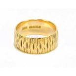 An 18ct yellow gold textured wedding band, approx size Q, approx weight 7.7g.