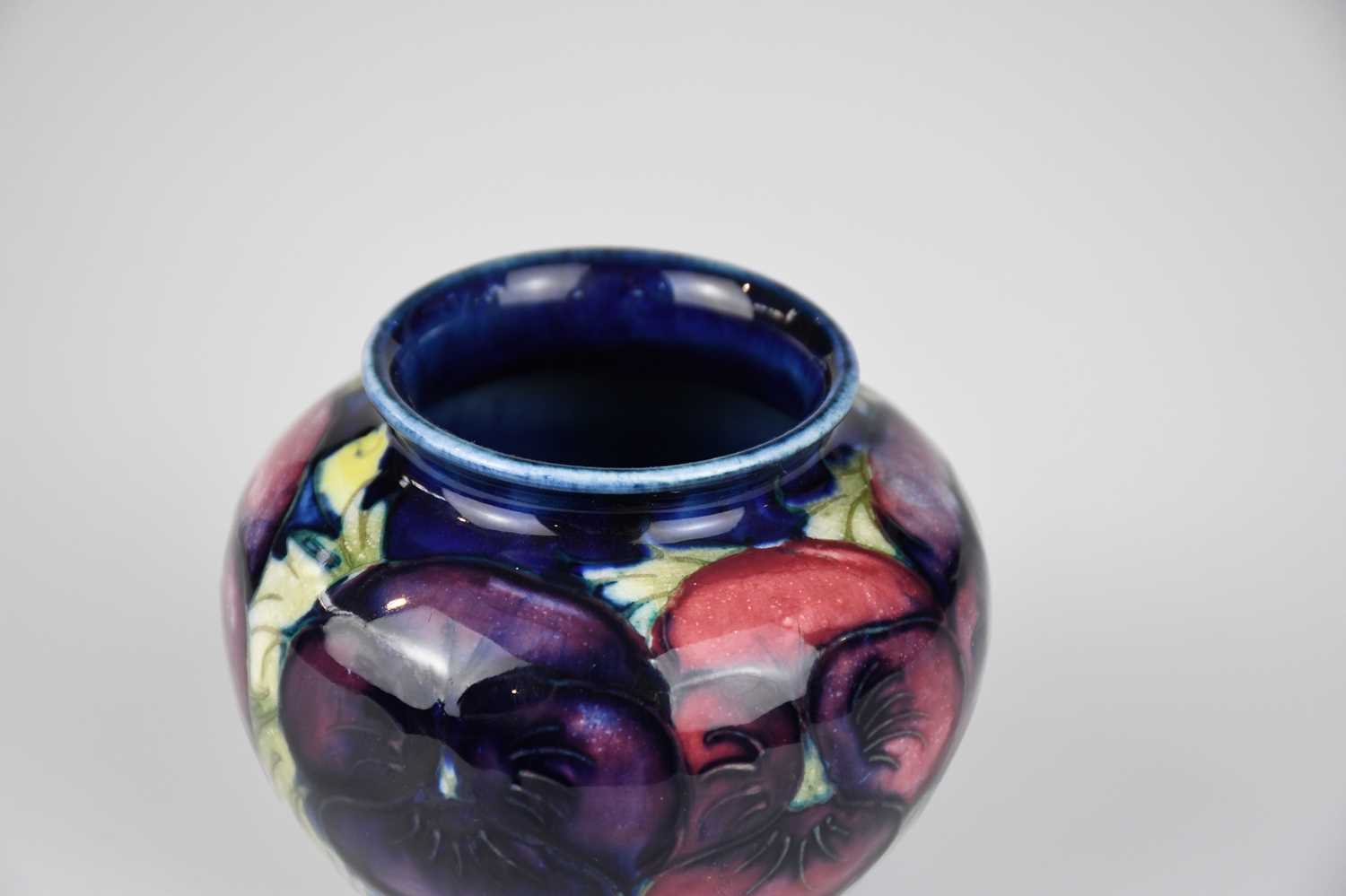 WALTER MOORCROFT; a squat vase in the 'Pansy' pattern on a blue ground, impressed marks to the - Image 3 of 4