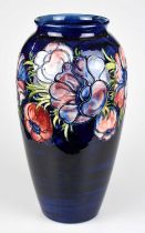 WALTER MOORCROFT; a large 'Anemone' pattern vase, decorated with flowers against a blue ground,