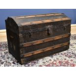 A late 19th/early 20th century vintage metal and wood bound dome top travelling trunk, with faux