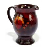 WILLIAM MOORCROFT; a jug with ribbed foot rim, decorated in the 'Leaf and Berry' pattern on a flambe