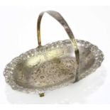 A Persian white metal bread basket with swing handle, with niello and pierced floral decoration,