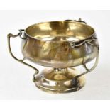 A George V hallmarked silver Arts and Crafts style three handled footed bowl, Birmingham 1912,