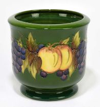 MOORCROFT; a jardinière decorated with fruits on a green ground, initialled and dated 80 to the