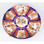 A late 19th century Japanese Imari charger decorated with fan shaped panels of flowers and Geisha,