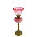 A late Victorian brass oil lamp, the cranberry and clear glass shade with etched floral decoration