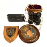 A pair of binoculars together with a Zeiss Icon filming camera, a Royal Navy shield and H.M.S