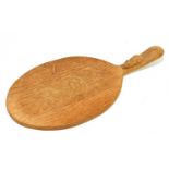 WORKSHOP OF ROBERT 'MOUSEMAN' THOMPSON; an oak cheese board, length 38cm.Condition Report: Water