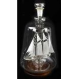 LYMINGTON GLASS; a contemporary glass model ship in a bottle, on turned wood base, height of