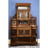 An Edwardian walnut display cabinet, the raised mirror back with two bevelled glass doors and two