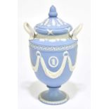 WEDGWOOD; a blue jasperware twin handled urn and cover, decorated with swags, impressed marks,