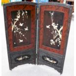 An early 20th century Japanese carved wood and lacquered two panel folding screen inlaid with bone