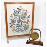 An early 20th century brass dinner gong on oak stand, together with an oak framed fire screen with