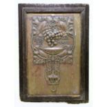 An Art Nouveau brass plaque of rectangular form, repoussé decorated with fruiting vines over a