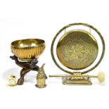 A brass circular gong, diameter 18cm, a Chinese brass bowl on hardwood stand, also a bell and a