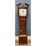 An early 19th century oak and mahogany crossbanded thirty hour longcase clock with arched pediment