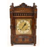 A large late 19th century oak cased mantel clock, the dial set with Roman numerals, with a white