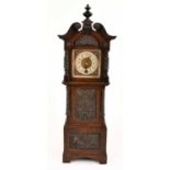 A miniature oak cased longcase clock, the dial set with Arabic numerals, with two carved panels to