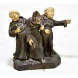 A German ceramic figure group of three drunken monks, height 22cm, length 24cm.