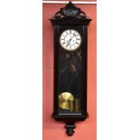 A late 19th century ebonised Vienna wall clock, the enamelled dial set with Roman numerals and