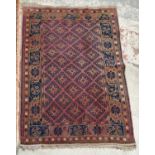 A semi antique Shiraz Persian rug in a Caucasian style with diamonds in dark blue on a wine red