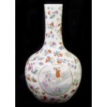 A Chinese porcelain Famille Rose vase with three circular panels painted with scenes of village