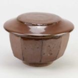 WARREN MACKENZIE (1924-2018); a faceted stoneware bowl and cover covered in iron rich glaze,