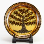 † PAUL YOUNG (born 1961); a slip decorated earthenware charger depicting a tree of life, impressed