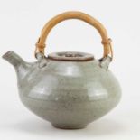 JOHN REEVE (1929-2012) for Leach Pottery; a stoneware teapot with cane handle covered in speckled