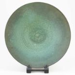 † ABDO NAGI (1941-2001); a stoneware charger/wall hanging covered in mottled green glaze with bronze