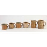 LINDA CHRISTIANSON (born 1952); two wood fired stoneware mugs, tallest 11cm, and a set of four