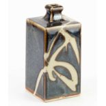 Mashiko Ware; a square stoneware bottle covered in cobalt and iron glaze with wax resist decoration,