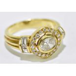 A yellow metal diamond ring with oval collet set stone approx. 0.66cts within a border of round