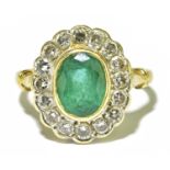 A yellow metal emerald and diamond oval cluster ring, size N, approx. 4.9g, ring head size 16.2 x