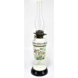 A Victorian opaque glass oil lamp with painted decoration, height to top of chimney 63cm.