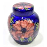 MOORCROFT; a ginger jar and cover decorated in the 'Anemone' pattern on a blue ground, bears green