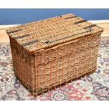 A wicker laundry basket, with metal straps, height 48cm, width 74cm, depth 47cm.
