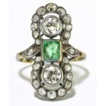 A yellow and white metal diamond and emerald Art Deco inspired ring, the twin principal rubover