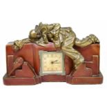 An Art Deco painted plaster mantel clock with shaped rectangular form, relief decorated with a