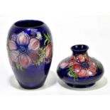 MOORCROFT; two vases decorated in 'Anemone' pattern on a blue ground to include an ovoid example,