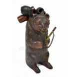 A Black Forest pipe stand modelled as a bear, housing five pipes, height 24cm. Condition Report: