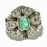 A white metal emerald and diamond ring, the rubover set emerald cut emerald within a stepped