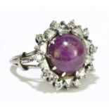 A white metal star ruby and diamond set large cluster ring, the claw set central ruby within a