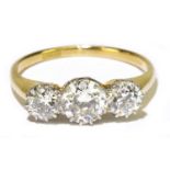 An 18ct yellow gold and diamond three stone graduated ring, the central round brilliant cut stone