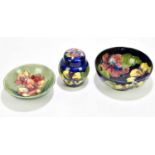 MOORCROFT; a Freesia pattern bowl, together with further 'Hibiscus' pattern bowl and lidded jar,