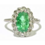 A platinum diamond and emerald cluster ring, the oval mixed cut emerald weighing approx 2.5ct,