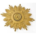 An Art Deco gilt plaster sunburst wall clock, the dial set with Arabic numerals, width 55cm.