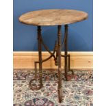 A 19th century cast iron table with circular wooden top supported on three fluted and scrolling
