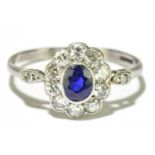An 18ct white gold platinum, sapphire, and diamond floral set ring with central rubover set sapphire